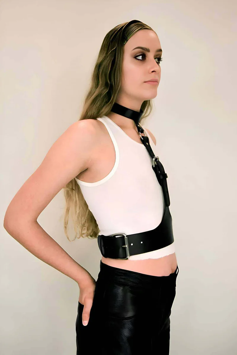 Close-up of silver buckle on black faux leather body harness chest strap
