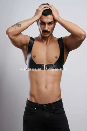 Black faux leather chest harness with silver buckle and adjustable straps on male model