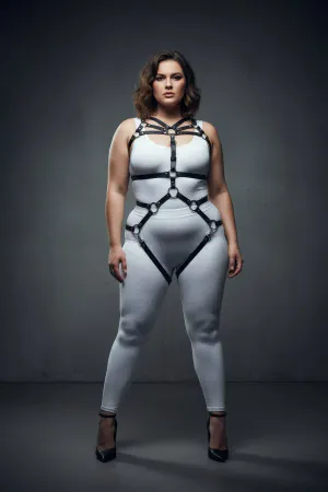Black faux leather full body harness with O-ring details and adjustable straps on a plus-size model.