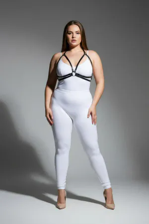 Black minimalist faux leather chest harness with central O-ring and adjustable straps worn by a plus-size model.