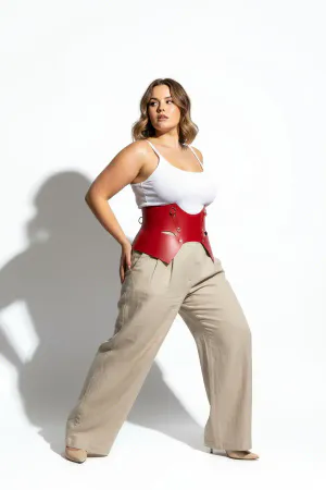 Red Faux Leather Waist Harness with Sculpted Panels on a woman in a cafe, light-colored blouse and pants