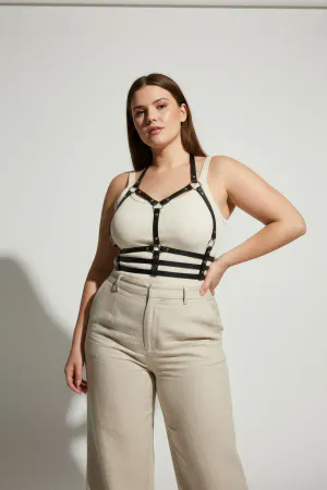 Black Vegan Leather Caged Chest Harness over beige top, featuring silver-toned stud details