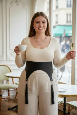 Black Faux Leather Corset Waist Harness with Tassels on a woman standing in a cafe